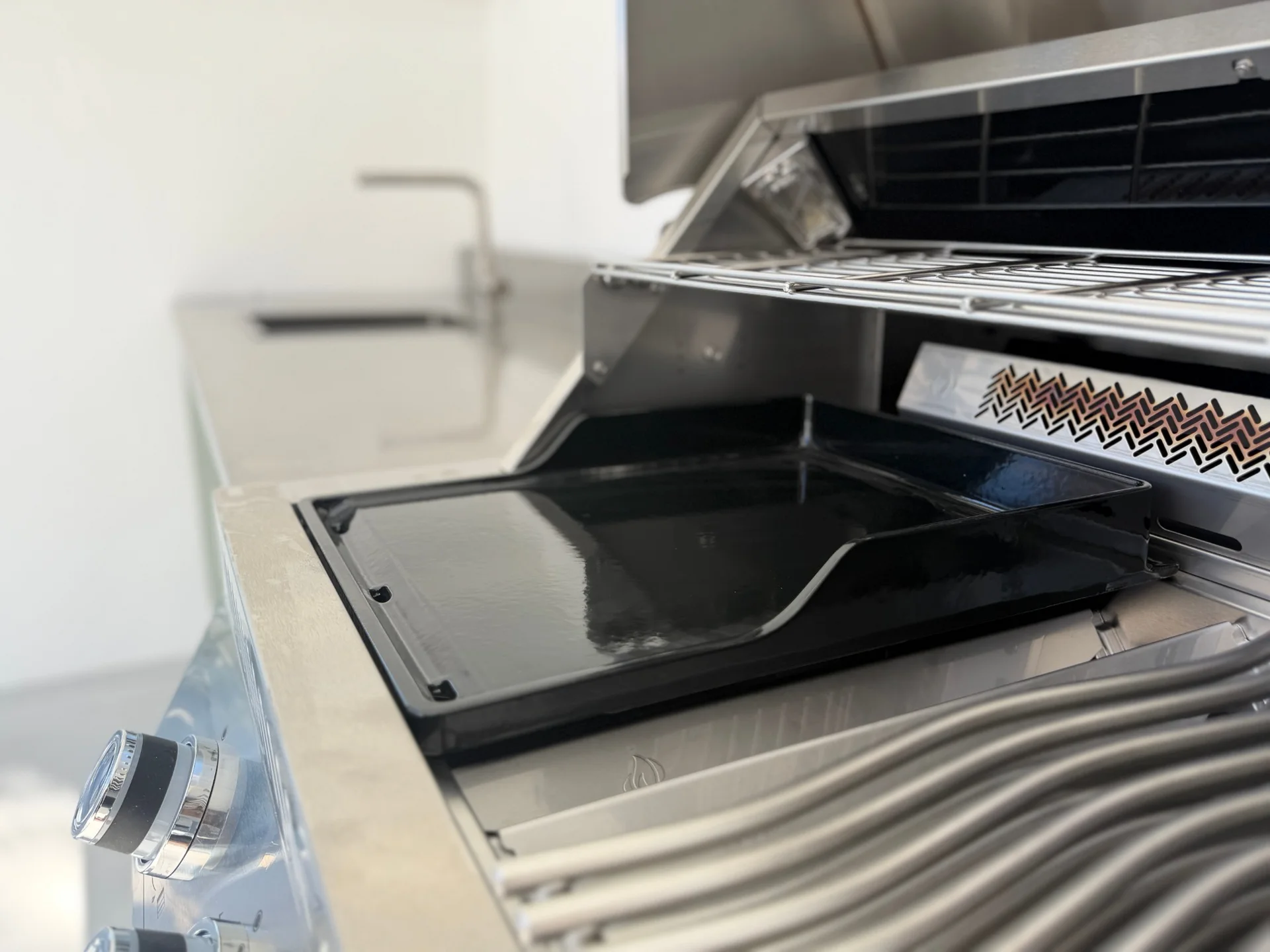 La plancha posée sur le barbecue de la cuisine EKZALT aux façades vertes, vue de dessus
