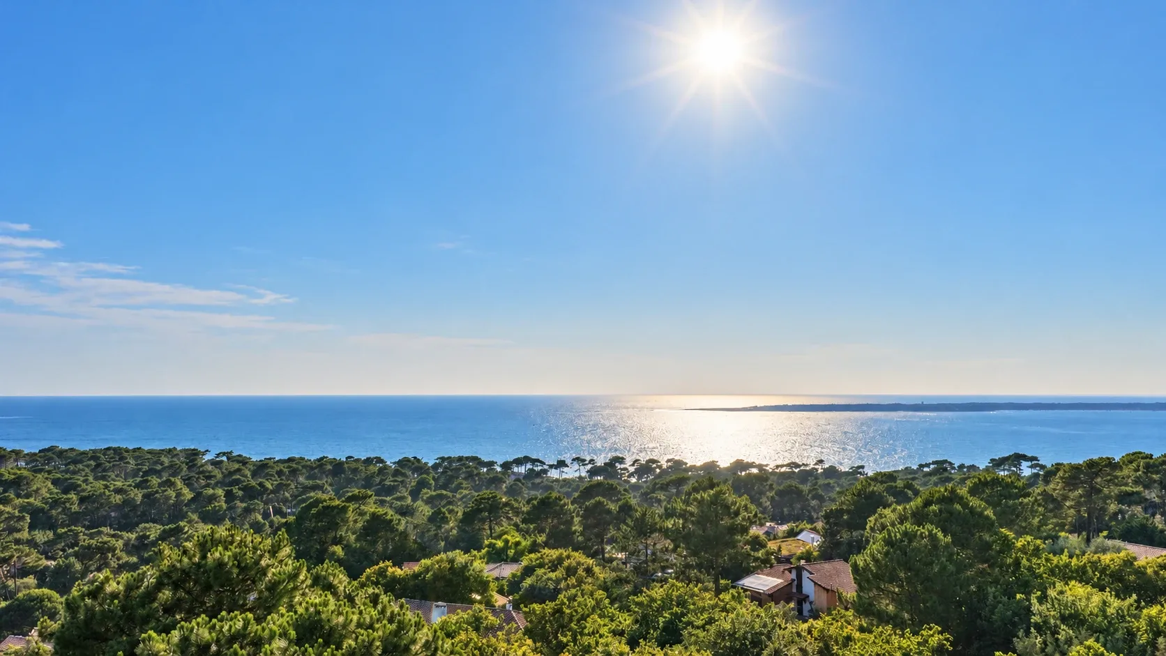 La forêt de pins du Pyla et le bassin d'Arcachon vus d'en haut, sous le soleil, le Cap Ferret à l'horizon